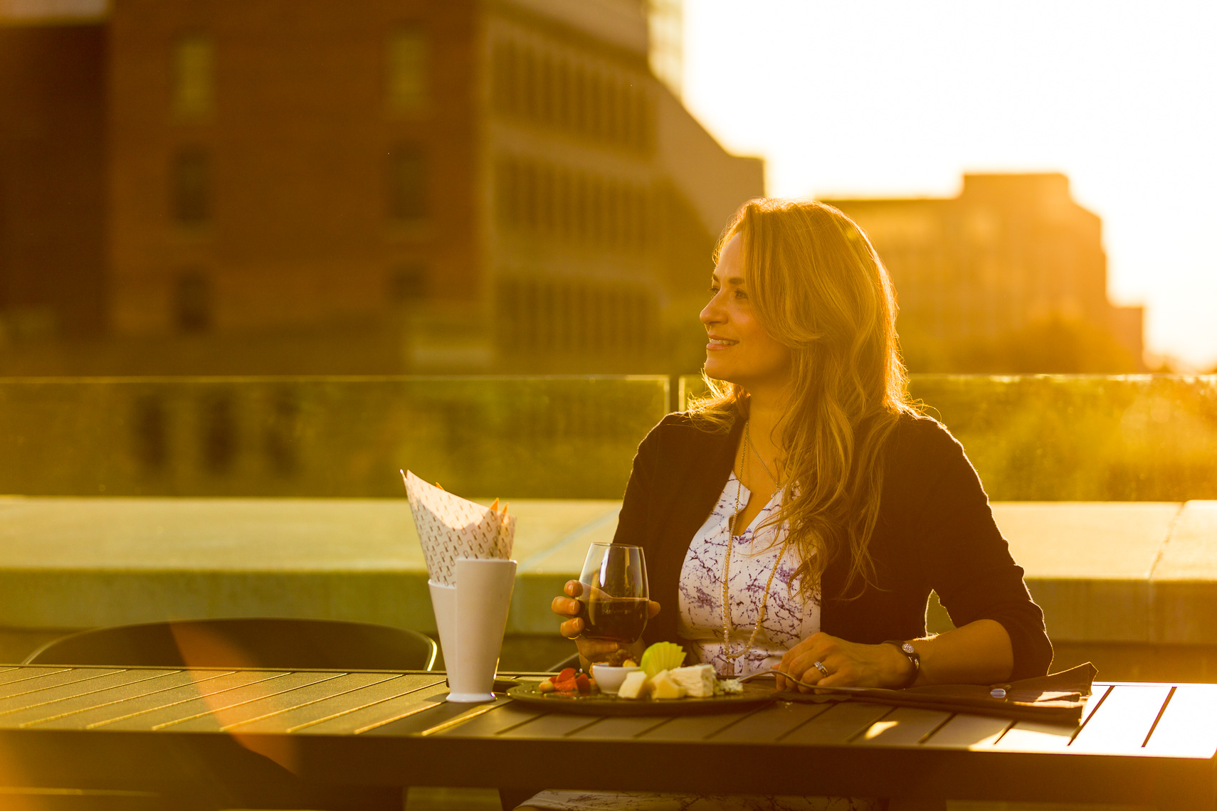 A woman dining and drinking on a rooftop restaurant in downtown Jacksonville Florida