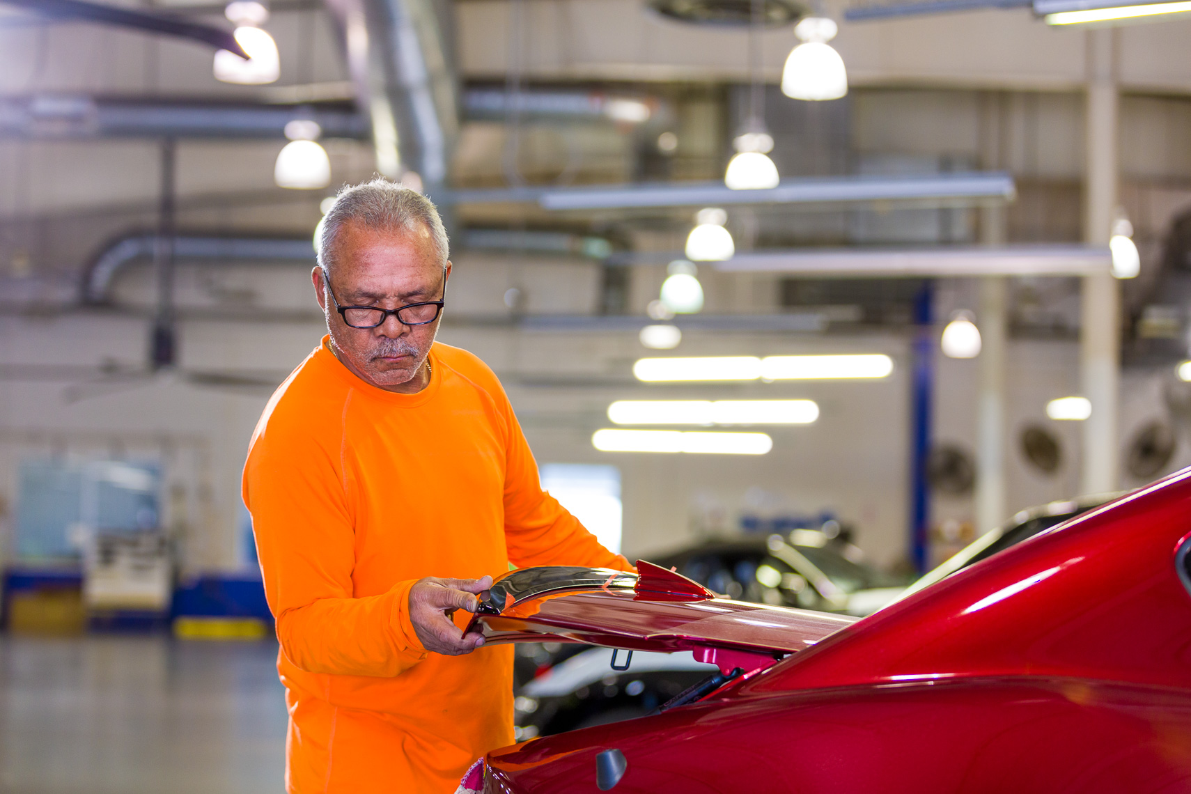 An industrial worker finishes automotive details before the product gets delivered