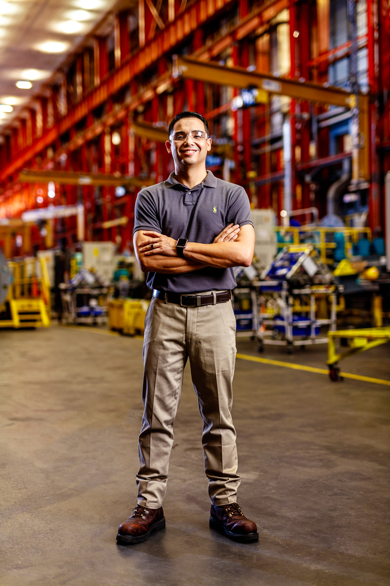 Portrait of an employee at a tech company in an inustrial warehouse